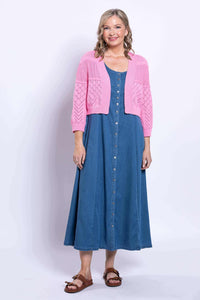 Full body front view of woman in pink pointelle cardigan and blue button-down dress