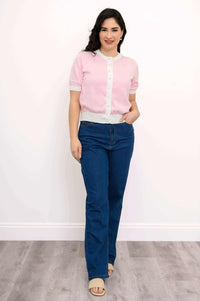 Full body front view of woman wearing retro two-tone pink sweater and jeans