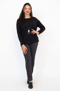 Full body front view of model in black Merino sweater and gray pants