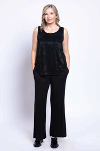 Full body front view of woman in black lace tank top and wide-leg black pants