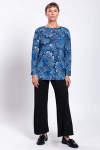 Full body front view of woman in blue botanical Margie top and black pants