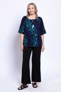 Full body view of a woman in a Luna Boho Peasant Top and black wide-leg pants
