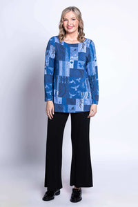 Full body image of model in blue patchwork tunic and black pants