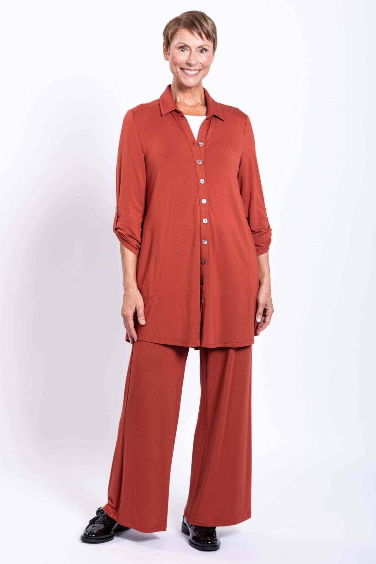 Full body image of model in rust oversized bamboo blouse and matching pants