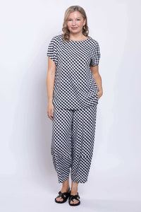 Full body view of woman in matching black and white gingham top and wide-leg pants