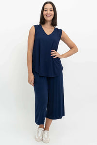 Full body view of a woman in a navy bamboo sleeveless top and wide-leg pants