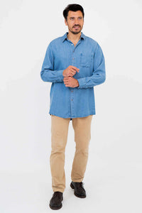 Full body view of man in light blue button-up shirt, tan pants and black shoes