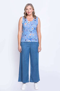 Full body view of woman in blue floral tank top and wide-leg denim pants