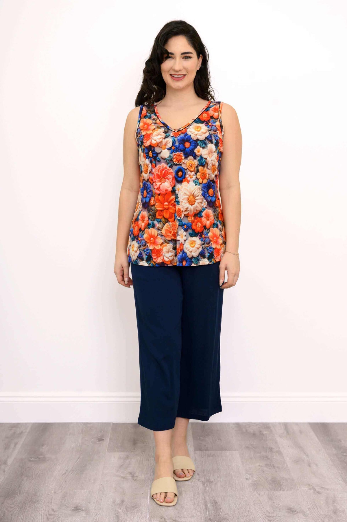 Full body view of woman in bright floral bamboo tank with navy pants
