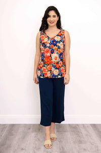 Full body view of woman in bright floral bamboo tank with navy pants