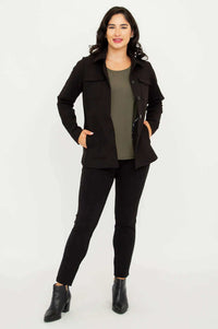 Full body shot of model in black jacket and pants, one hand in pocket