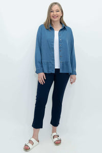 Full body view of a woman modeling a blue Tencel denim blouse and navy pants