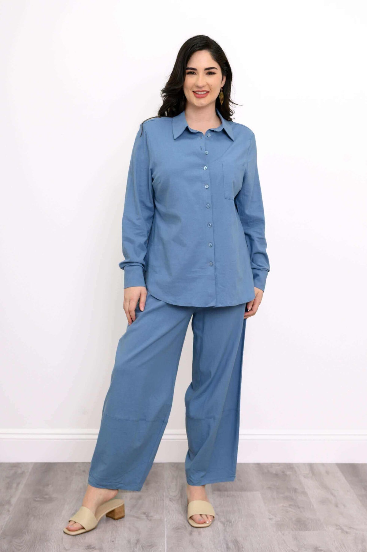 Full view of woman modeling a blue spread-collar shirt with matching wide-leg pants