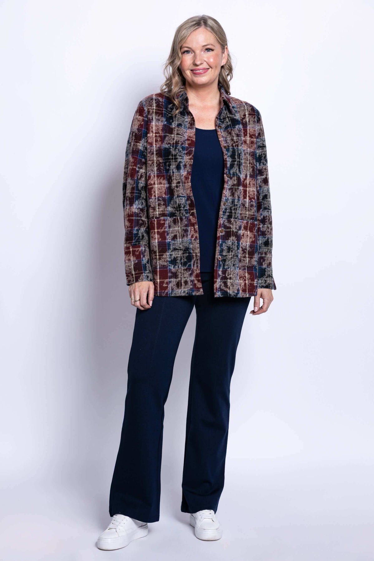 Full length shot of a woman wearing a multi plaid cotton button down jacket and dark navy pants.