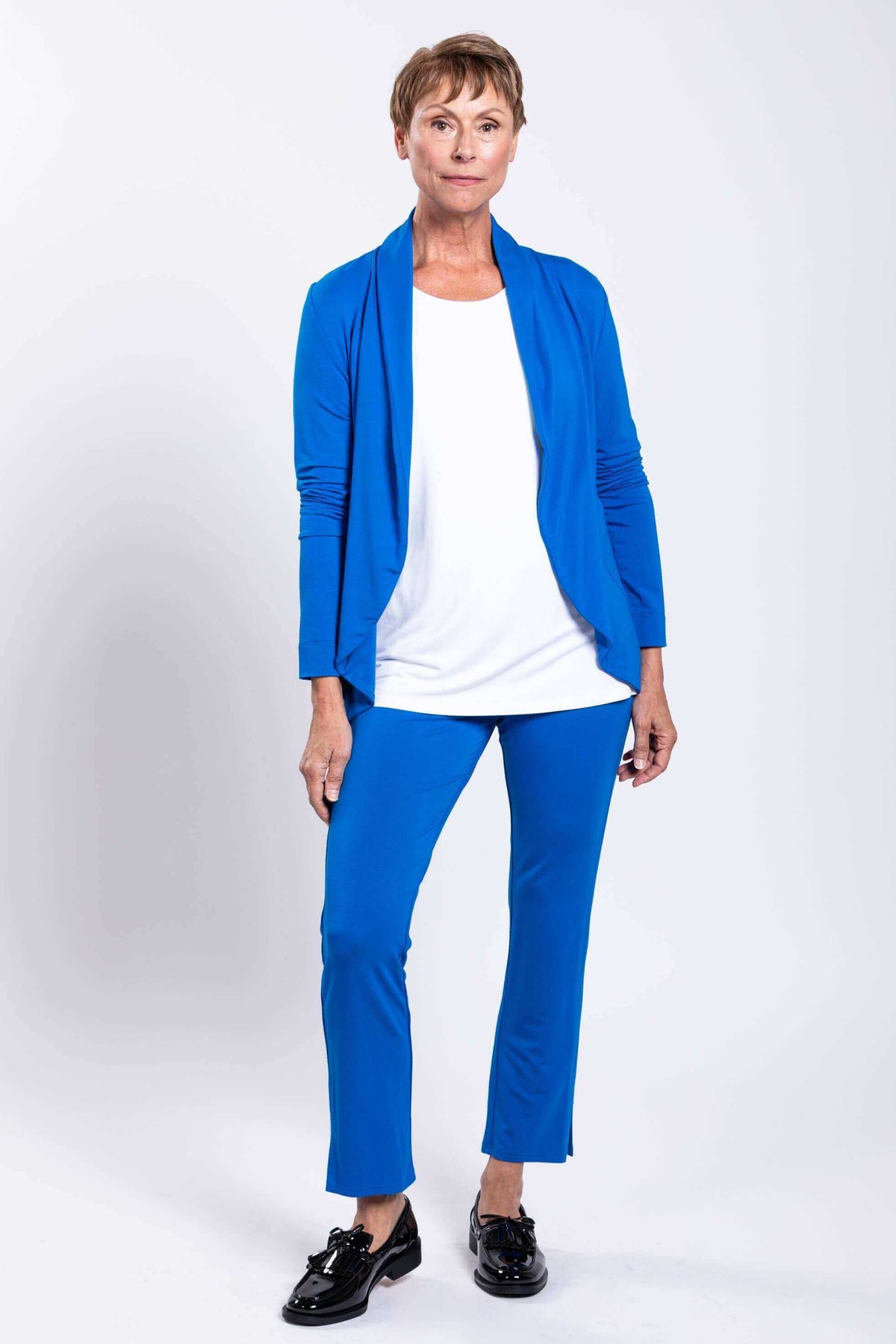 Full body shot of woman in layered blue French Terry jacket with white inner top