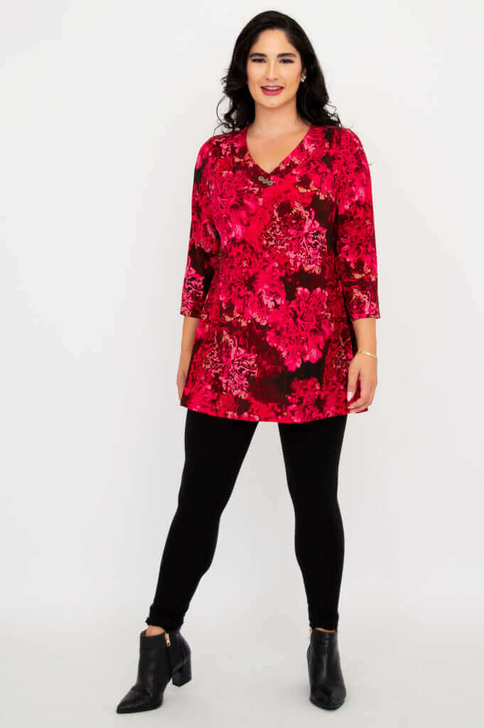 Full body shot of woman standing in pink floral Vana tunic and ankle boots