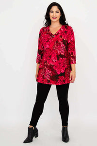 Full body shot of woman standing in pink floral Vana tunic and ankle boots