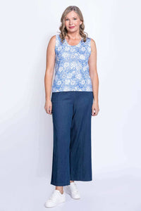 Full body front view of woman in blue floral tank top with wide-leg pants