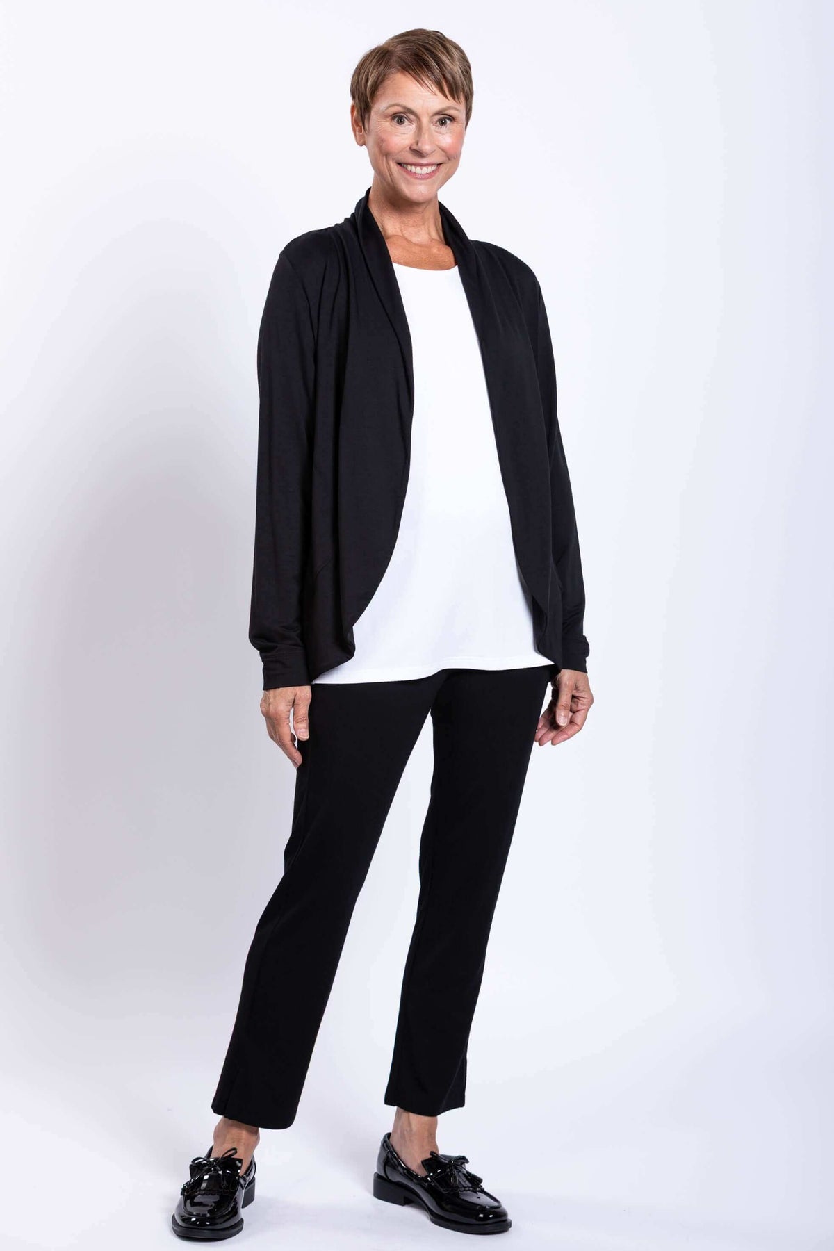 Woman standing in a black French Terry jacket, white shirt, and black pants
