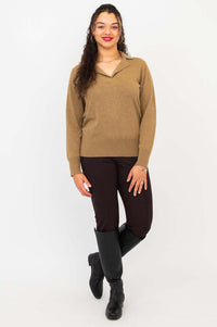 Full body view of model in brown V-neck sweater, dark pants, and black boots