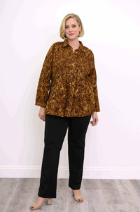 Full body view of woman modeling an autumn gold smocked button-up shirt with black pants