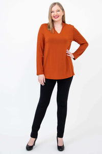 Full view of model posing in a rust bamboo V-neck long sleeve top and black pants