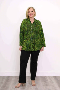 Woman wearing green leaf print smocked top with black pants, full body view