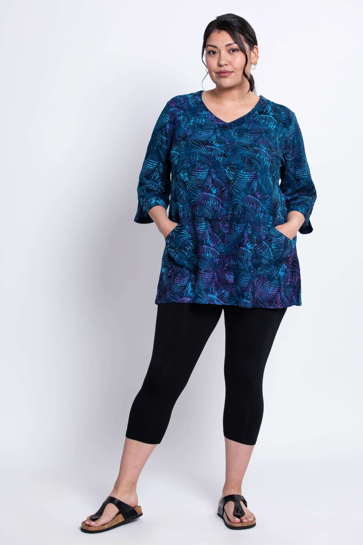 Model in Evelyn Top lagoon blue, full body view with patch pockets and black leggings