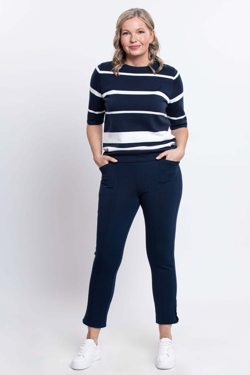 Full body view of woman in Serena navy and white striped sweater and navy pants