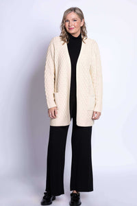 Full body view of woman modeling cream cable knit cardigan over black outfit