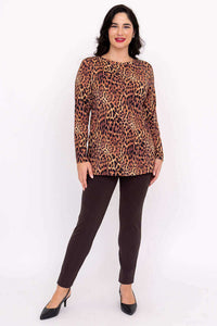 Full body view of a woman modeling a leopard print long sleeve top and brown pants