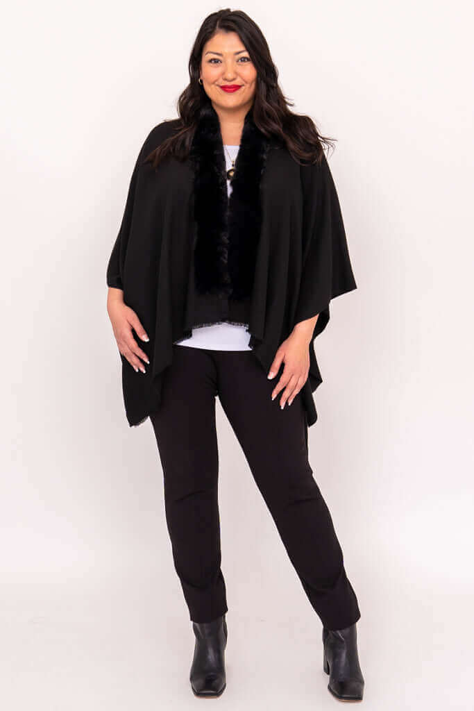 Full body view of a woman in a black wrap and pants, standing straight