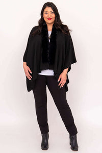Full body view of a woman in a black wrap and pants, standing straight