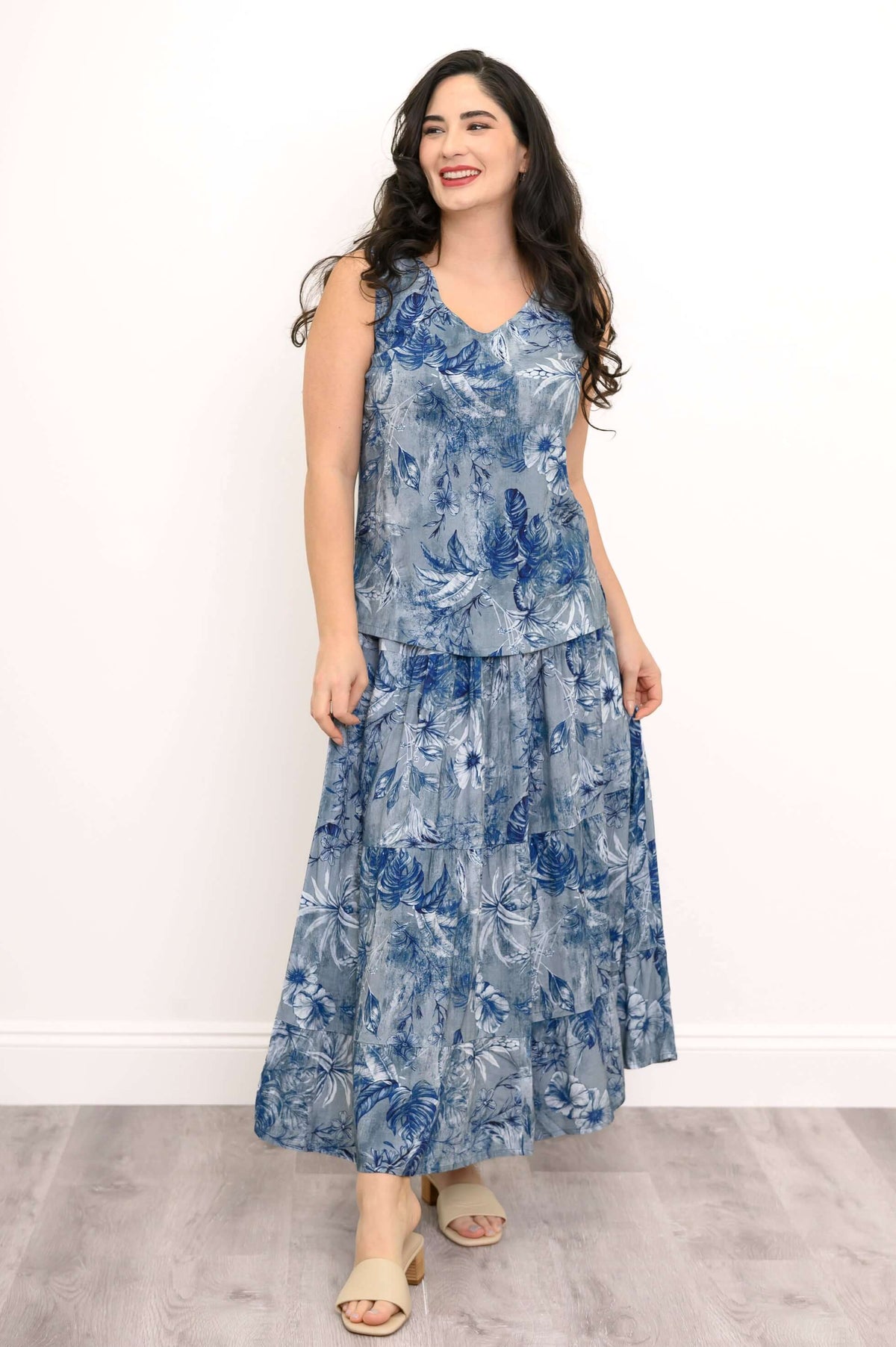 Full view of woman in blue floral V-neck tank top and matching long skirt