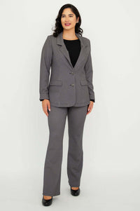 Full body view of a woman in a checkered blazer and pants suit set with black shoes