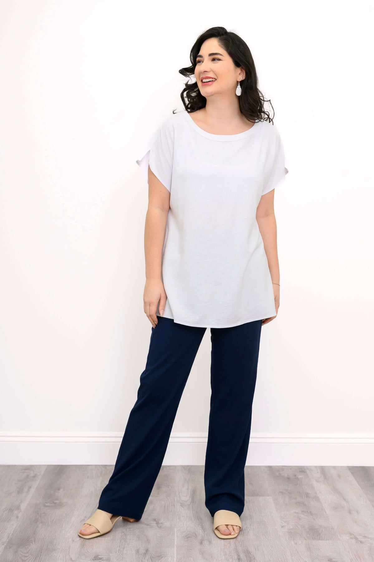 Full body view of model in white Aria Tee paired with navy pants
