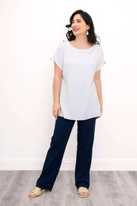 Full body view of model in white Aria Tee paired with navy pants