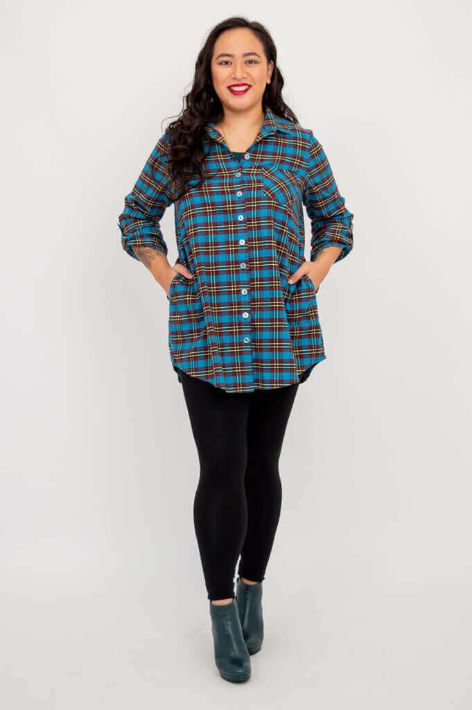 Full body view of model in blue plaid flannel tunic with black leggings
