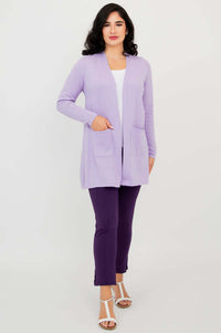Full body view of woman in light purple open front cardigan, white top, and dark purple pants