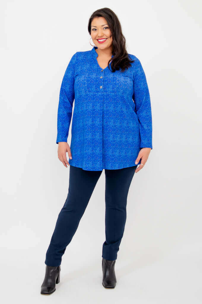 Full body view of model in a blue bamboo tunic and navy pants with black boots