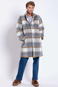 Full body view of woman in plaid wool coat, hands in side pockets