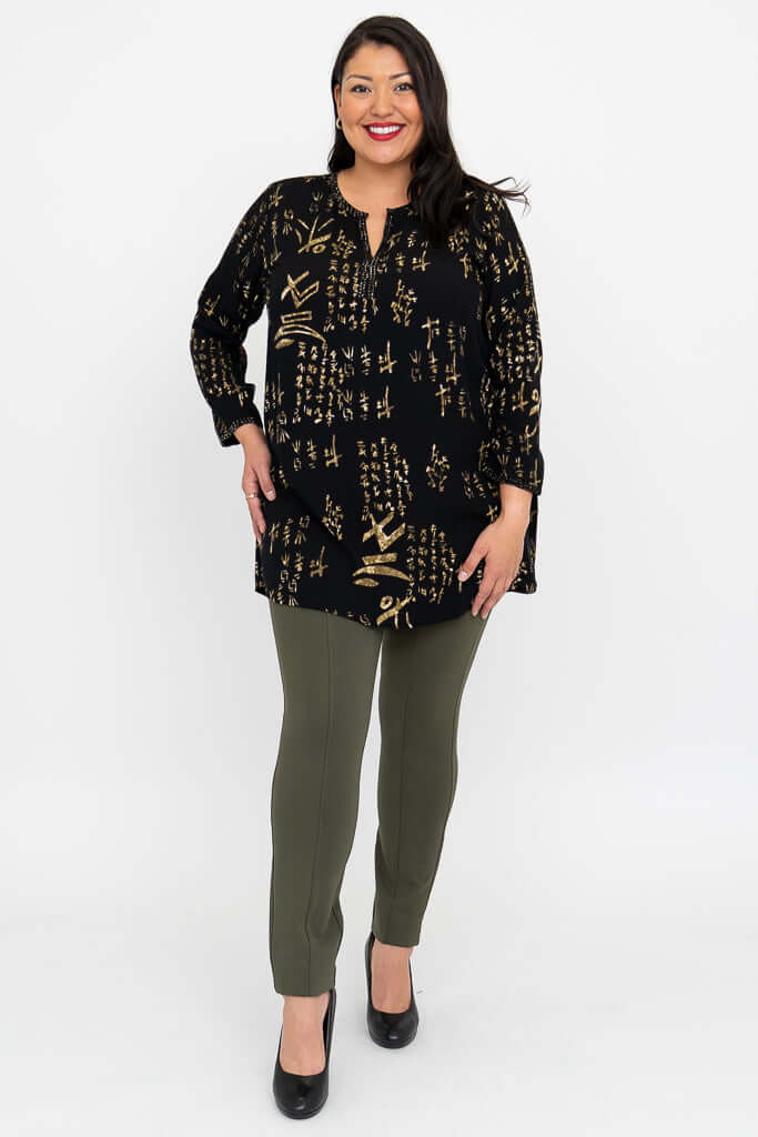 Full body view of woman in black gold batik blouse and olive pants