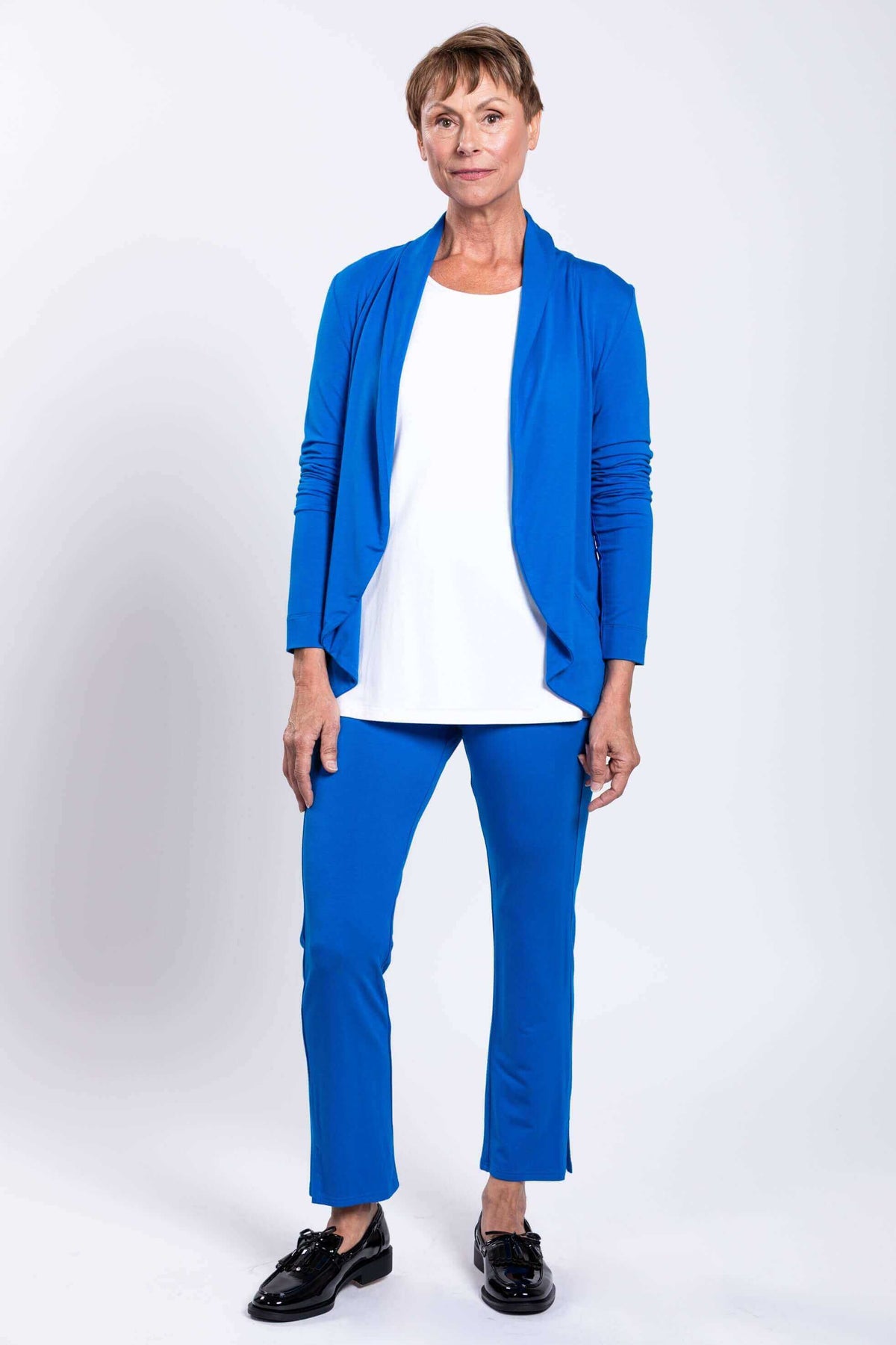 Full body view of woman in blue French Terry jacket and matching pants against a white background