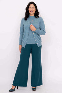Full body view of woman in blue cardigan and teal wide-leg pants