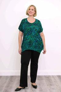 Full-length view of woman in green and blue leafy print tunic top and black pants