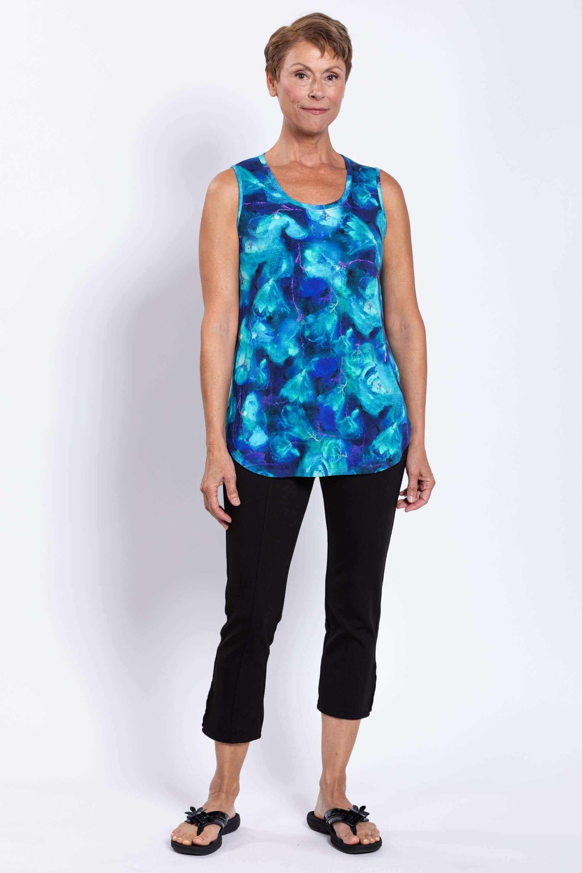Full body view of woman in sleeveless blue Jazz Tank and black cropped pants