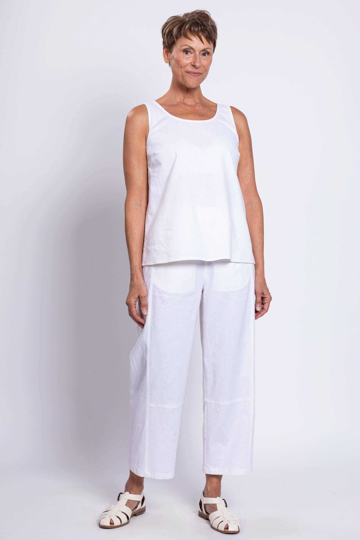Full body view of woman in white sleeveless tank top and matching pants
