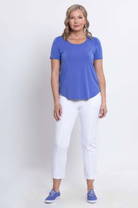 Full body view of woman modeling blue Tessa Tee with white pants and sneakers