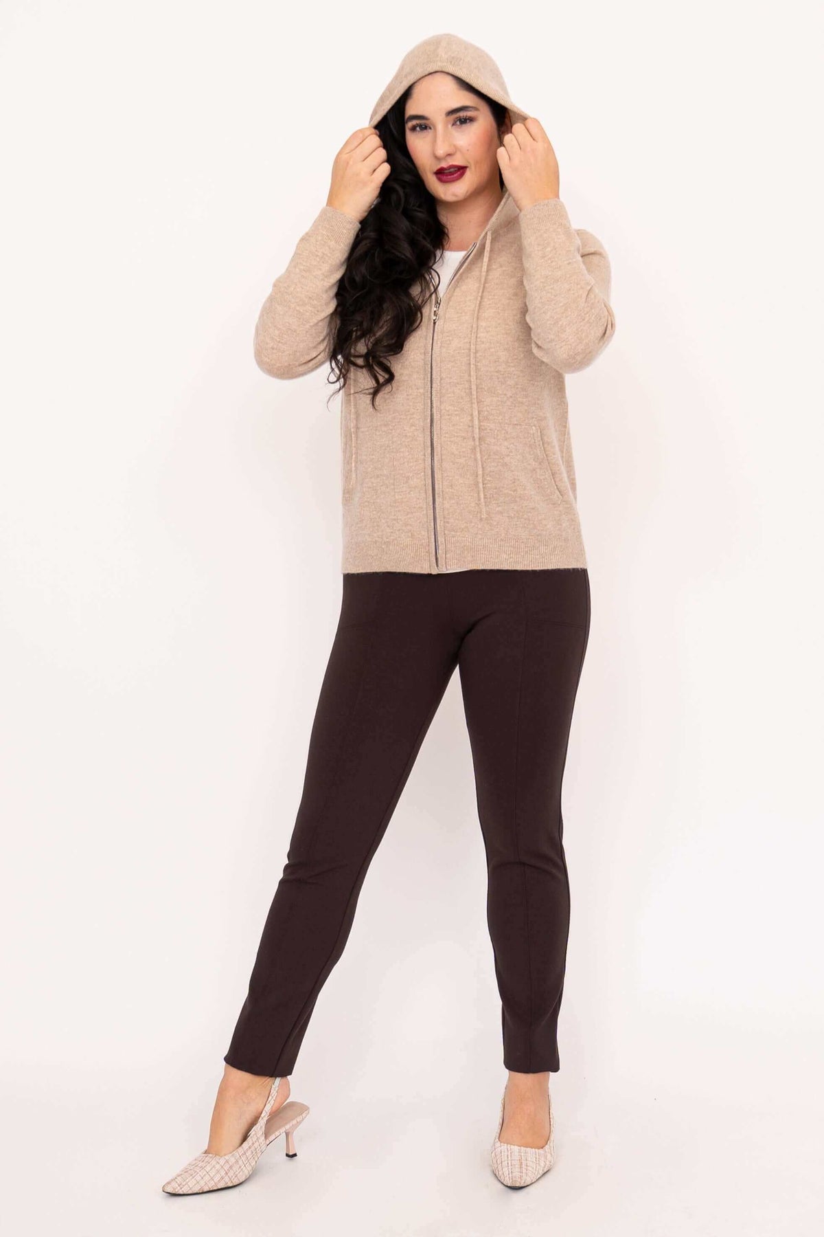 Woman wearing beige hoodie with hood up, full body view