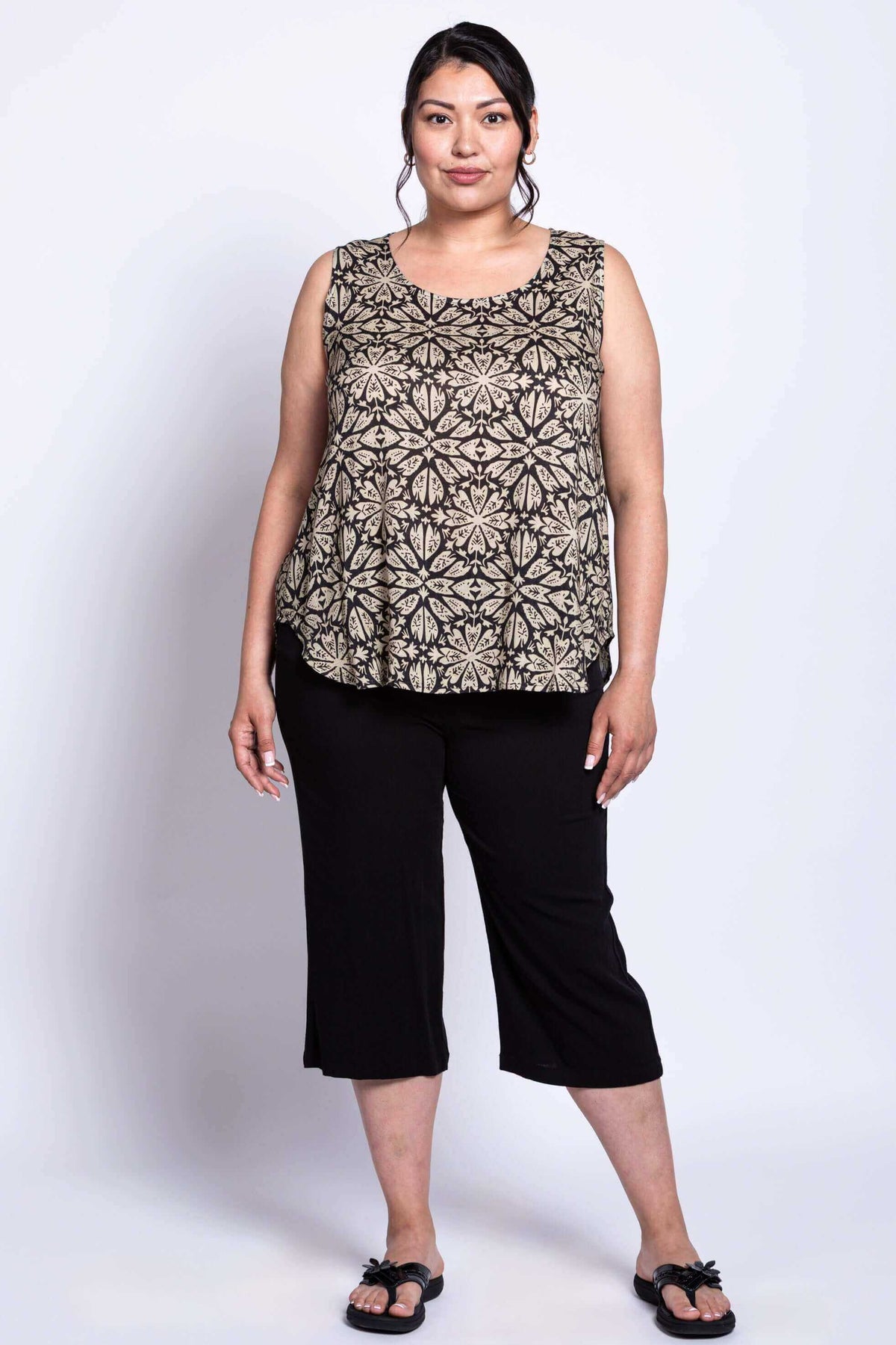 Full body shot of model wearing black and beige geometric print tank to and black capri pants